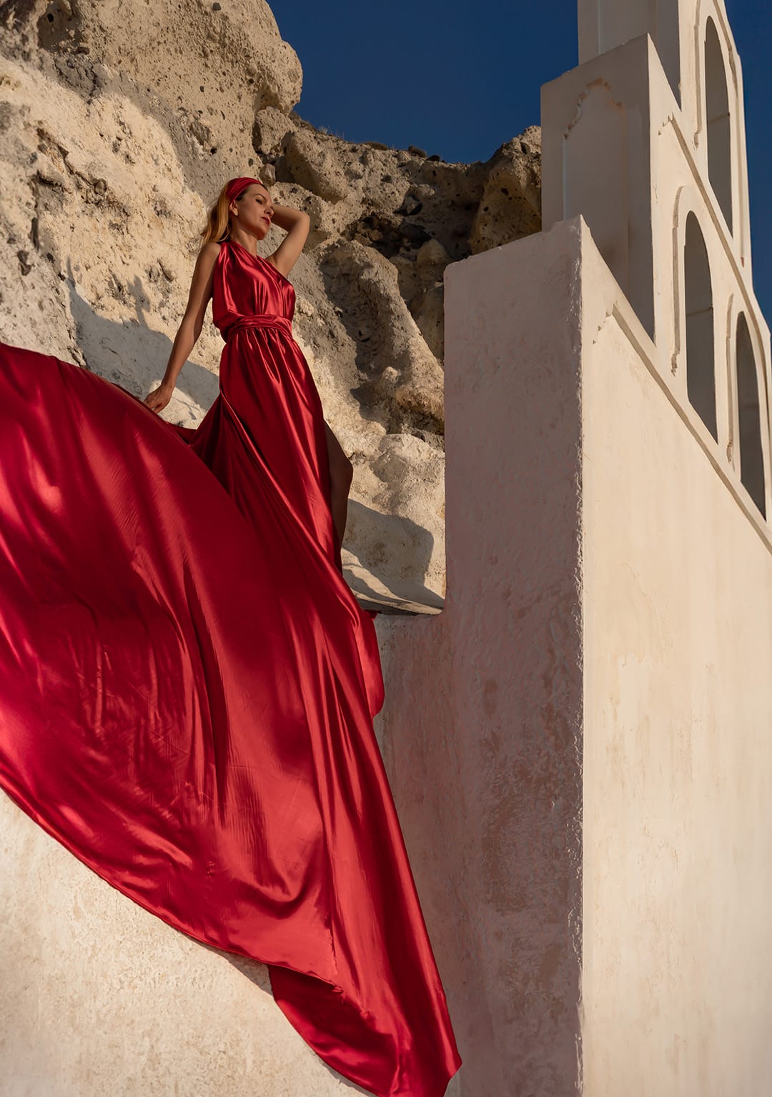 Piękna kobieta stoi w czerwonej sukni flying dress, patrzy w dal na morze, WeddAtelier MIchał Dubicki