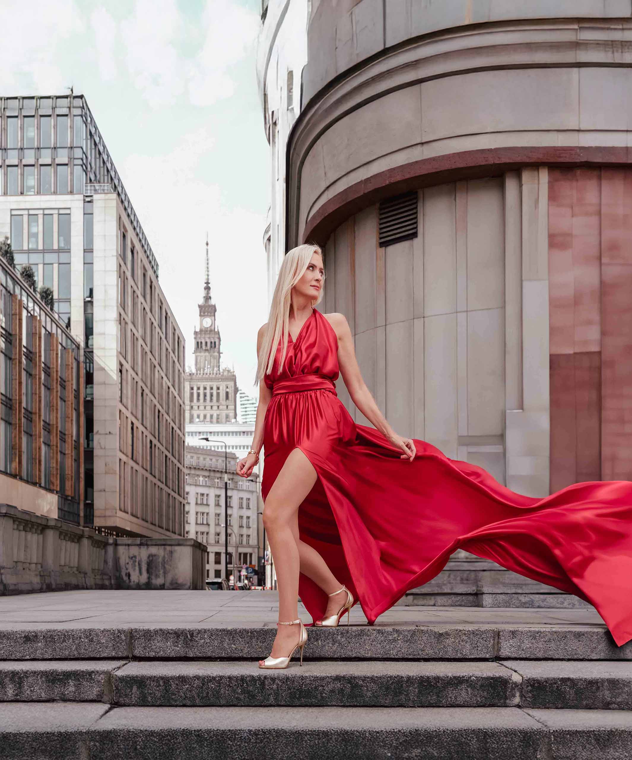 Sesja zdjęciowa w sukniach Flying Dress w Warszawie, modelka w długiej czerwonej sukni, w tle Pałac Kultury i Nauki, Fotograf Ślubny Warszawa WeddAtelier.pl Fotografia i Film Ślubny