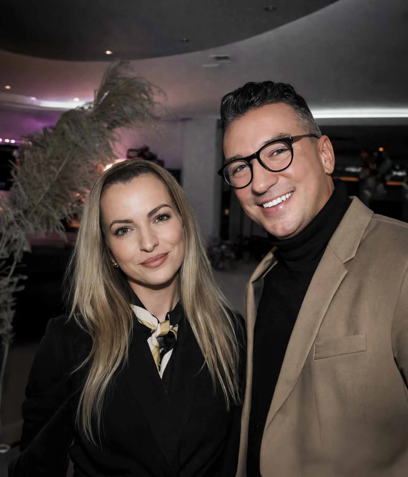 Portret fotografa ślubnego z Warszawy WeddAtelier - kobieta i mężczyzna w eleganckich strojach, podczas ślubu na sali weselnej